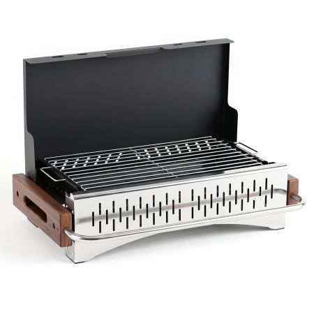 Barbecue a carbone portatile con griglia regolabile in altezza, ideale per cucinare in giardino o in campeggio.