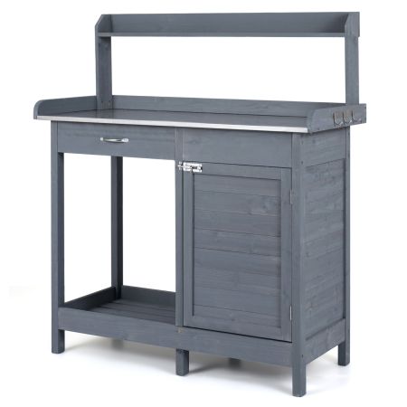 Tavolo da giardinaggio in legno massello con piano in acciaio inox, cassetto, armadietto e ripiani aperti per organizzazione.